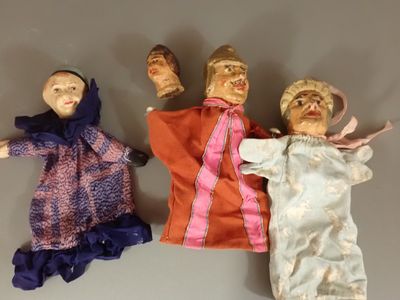 Trois poupées en tissu sont alignées sur une table