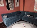 un grand canapé bleu dans un coin du salon