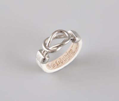 un gros plan d'une bague en argent ornée d'un nœud