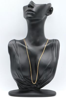 a black mannequin with a gold chain on it