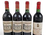 three bottles of red wine sit next to each other on a white surface