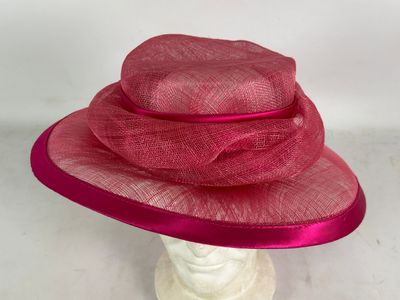 un gros plan sur un chapeau rose posé sur une tête de mannequin