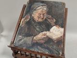 tableau représentant une vieille femme en train de lire un livre sur un chevalet en bois