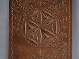 an image of a wooden plaque with a flower design on it