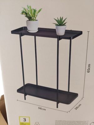 une étagère noire sur laquelle sont posées deux plantes en pot