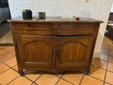 a wooden cabinet with a marble top on a tiled floor
