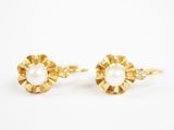 une paire de boucles d'oreilles en perles et or sur fond blanc