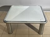 a small table with a glass top on a tiled floor