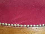 a close up of a red velvet covered chair