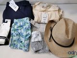 un chapeau, une chemise, un pantalon et d'autres articles disposés sur une table