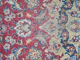 an antique persian rug with a red background and blue, yellow, and red floral design
