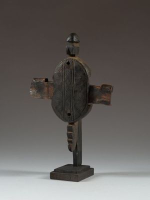 an image of a wooden cross on a stand against a gray background