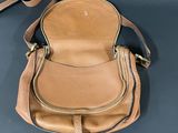 a close up of a purse on a table with a strap around it