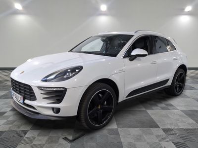 Une Porsche Cayenne blanche est garée dans une grande pièce.