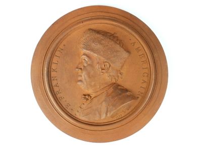 une image représentant un médaillon en bronze à l'effigie d'un homme
