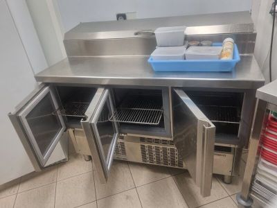 un plan de travail en acier inoxydable sur lequel est posé un bac bleu