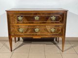 a small wooden chest of drawers on a tiled floor