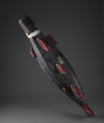 une sculpture en bois représentant un poisson sur fond noir