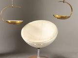 une chaise blanche et une assiette dorée suspendue au plafond