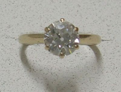 une bague sertie d'un diamant, posée sur une table