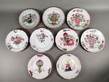 six assiettes ornées de motifs floraux sont disposées sur un fond gris