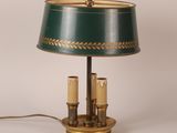 une lampe de table verte et dorée sur laquelle sont posées deux bougies