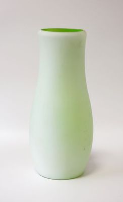 a small green vase sitting on a white surface