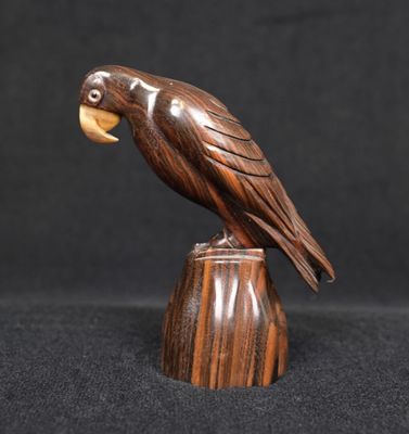 une sculpture en bois représentant un oiseau perché sur une souche de bois