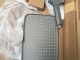 a box with a shower head and a shower brush on it