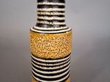 a black and white vase with yellow stripes on it