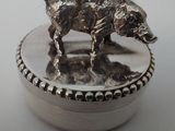 une boîte en argent ornée d'un chien, posée sur une table