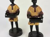 pair of african figurines of a woman holding trays of food