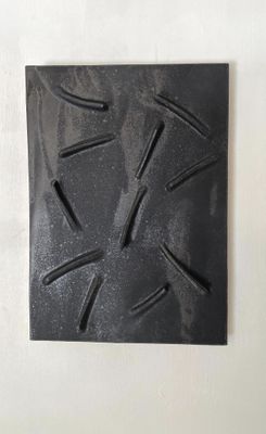 une plaque noire clouée sur un mur blanc