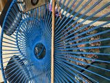 a blue fan sitting on top of a table next to a chair
