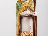 une figurine représentant un homme avec un chapeau et une canne