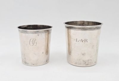 une paire de coupes en argent portant des initiales sur un fond blanc