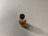 a small bottle of liquid sitting on a table