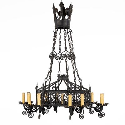un grand lustre en fer forgé à cinq branches et une couronne
