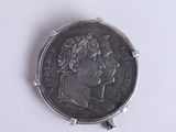 a silver coin with a picture of a woman on it
