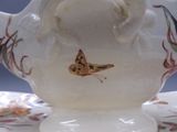 un vase blanc sur lequel est peint un papillon