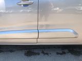 the door handle of a silver car with a person taking a picture of it
