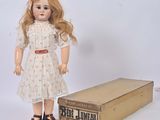 a doll that is standing next to a box