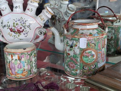 many vases and cups on display in a glass case