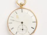 une montre de poche en or avec des chiffres romains sur le cadran