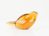an orange glass bird sitting on top of a white surface