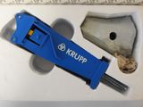 a blue krupp tool in a box next to a piece of paper