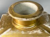 a gold vase with a painting on it on a table