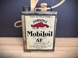 a can of gasoline sitting on a table next to a clock