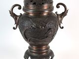 un vase en bronze surmonté d'un dragon