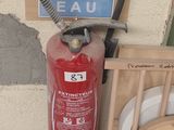 un extincteur à côté d'une chaise et une borne d'incendie